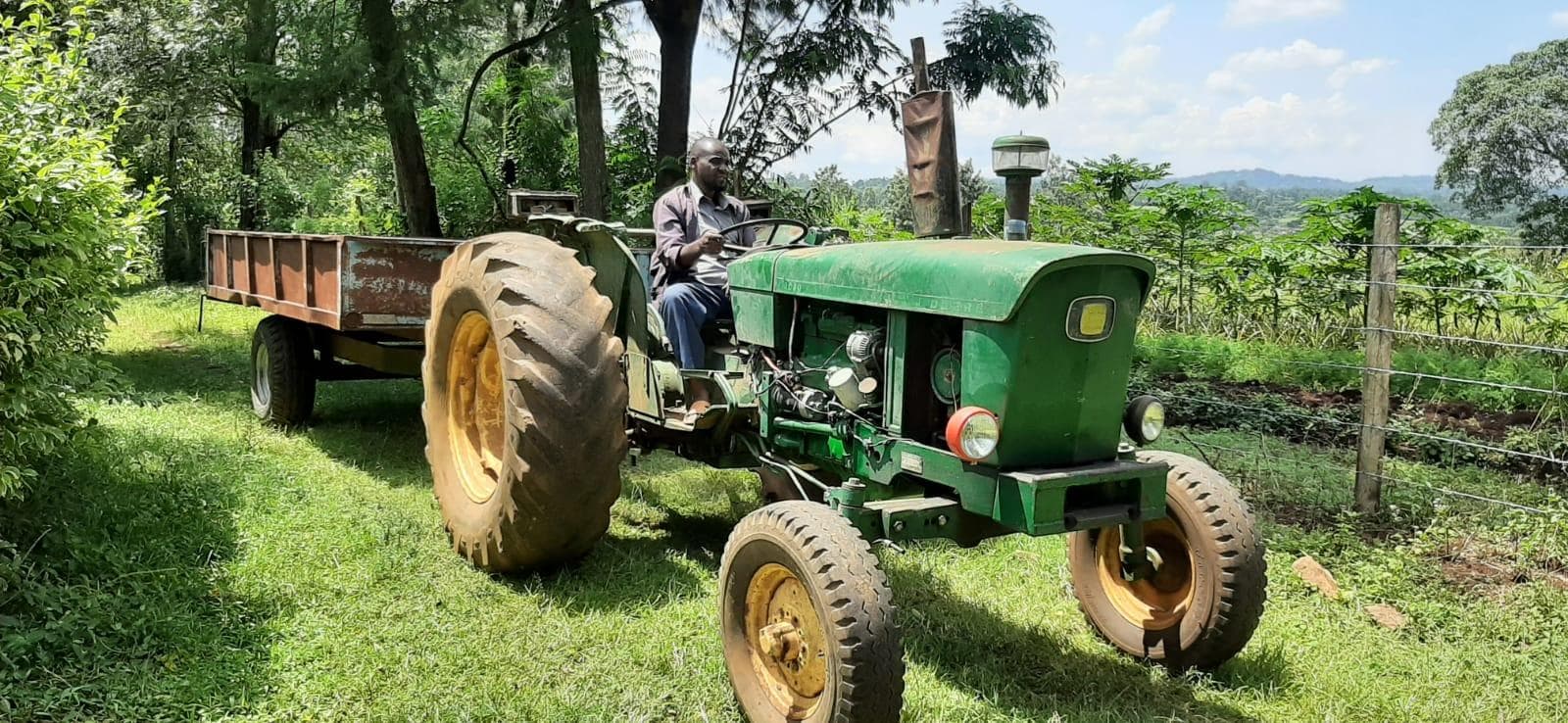 Farmer on green tractor at OKIRAT farm